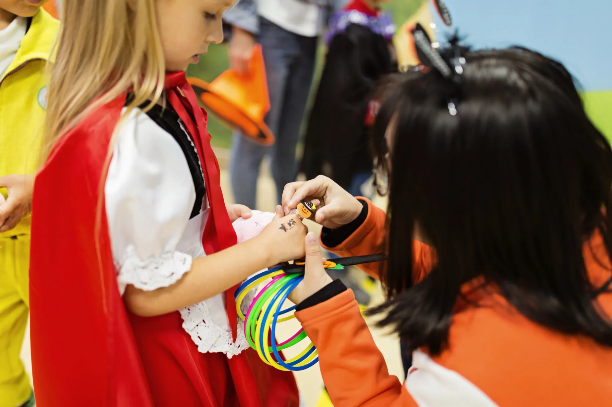 A child putting a sticker on a costume at a school event