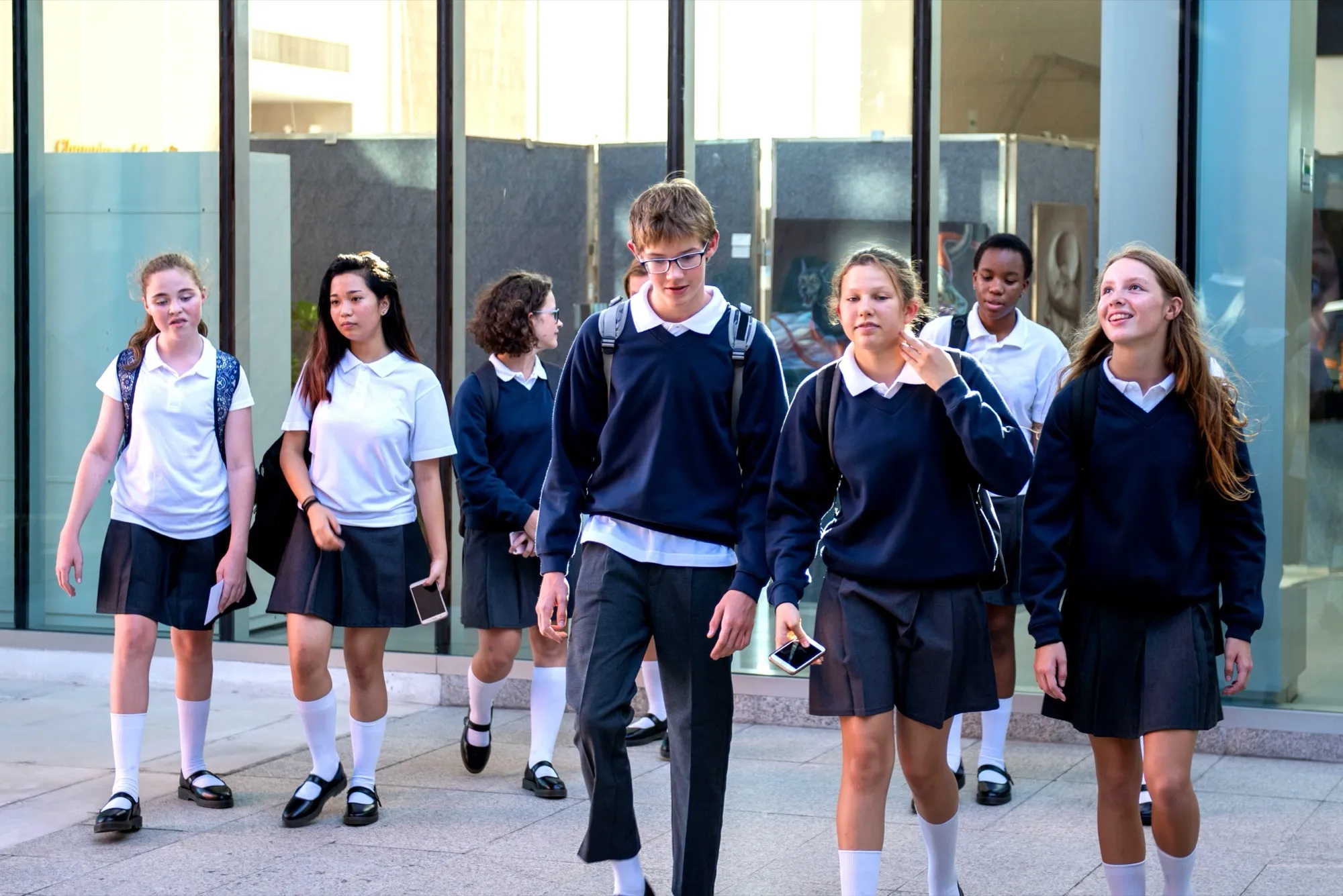 Teenage students in school uniform walking together